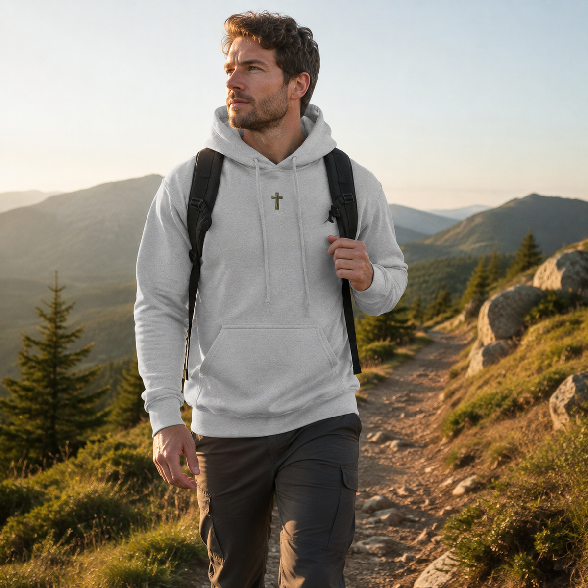 Ash grey Cross hoodie worn hiking on a sunlit mountain trail